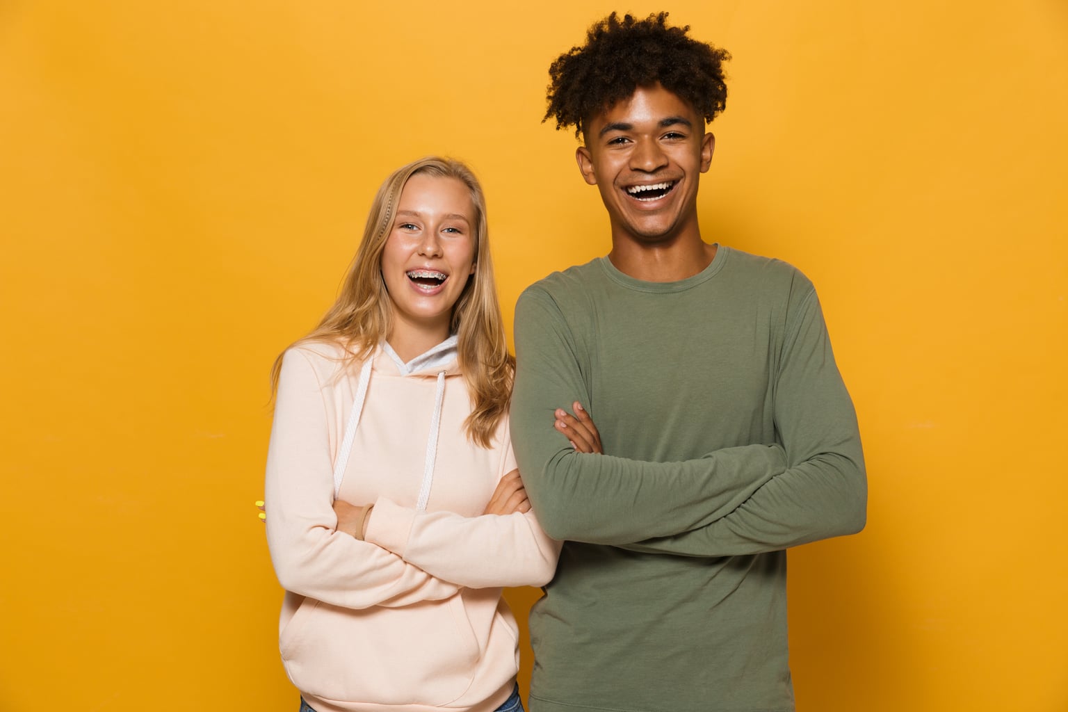 Two teenagers smiling with braces