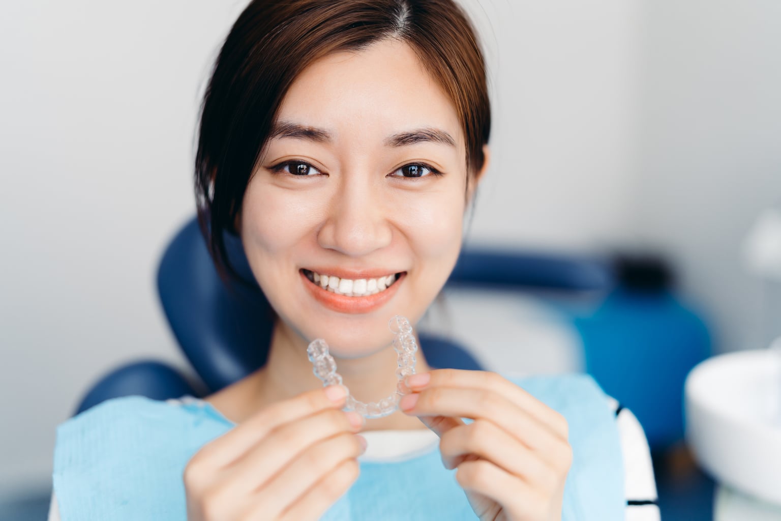 Patient holding a clear Invisalign aligner